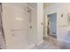 Bright bathroom featuring a walk-in shower with grab bars and an open doorway at 2265 S Depew St, Denver, CO 80227