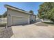 Spacious two-car garage with concrete driveway and adjacent landscaping on a sunny day at 2265 S Depew St, Denver, CO 80227
