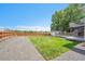 Expansive fenced backyard with a well-maintained lawn, shed, and deck, offering privacy and space at 12366 Elm Way, Thornton, CO 80241