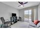 Functional bedroom with a ceiling fan, television, and a sliding glass door leading to a balcony at 12366 Elm Way, Thornton, CO 80241