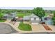 The two-story home features neutral siding, stone accents, an attached garage, and a well-manicured lawn at 12366 Elm Way, Thornton, CO 80241