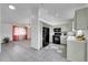 Open layout showcasing kitchen with black appliances, tiled flooring, and an adjoining living area at 12366 Elm Way, Thornton, CO 80241