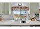 Bright kitchen window with scenic views above a white, double-basin sink at 12366 Elm Way, Thornton, CO 80241