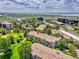 Aerial view of a building complex, golf course and surrounding landscape, offering a scenic overview of the location at 3144 S Wheeling Way # 206, Aurora, CO 80014