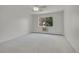 An empty bedroom with a window, offering a view of greenery outside and an air conditioning unit at 3144 S Wheeling Way # 206, Aurora, CO 80014