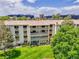 Exterior shot of a multi-story apartment building with balconies, surrounded by green lawns and trees at 3144 S Wheeling Way # 206, Aurora, CO 80014