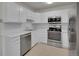 Kitchen featuring all-white cabinetry, modern stainless steel appliances, white countertop, and bright overhead lighting at 3144 S Wheeling Way # 206, Aurora, CO 80014