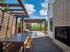 Outdoor entertaining on the spacious back deck featuring a fireplace and dining under a pergola at 6096 W Keene Ave, Denver, CO 80235