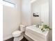 Well-lit powder bath with floating vanity, modern fixtures, and a large mirror at 6096 W Keene Ave, Denver, CO 80235