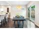 Open dining area featuring a modern chandelier, a long dining table, and sliding glass doors to the outside at 6096 W Keene Ave, Denver, CO 80235