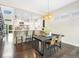 Dining area open to a kitchen with a large center island and hardwood floors in an open-concept design at 6096 W Keene Ave, Denver, CO 80235