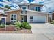 Contemporary two-story home featuring a brick accent, a two-car garage, and professional landscaping at 6096 W Keene Ave, Denver, CO 80235