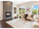 Cozy living room with a modern fireplace, hardwood floors, and large windows offering scenic views at 6096 W Keene Ave, Denver, CO 80235