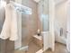 Modern shower with neutral tile, a glass door, and a built-in bench at 6096 W Keene Ave, Denver, CO 80235