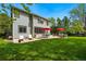 Wide backyard with a stone patio, dining and lounge seating, lush green lawn and mature trees at 531 Americana Rd, Longmont, CO 80504
