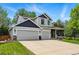 Beautiful two-story home with a three-car garage, manicured lawn, and inviting front porch with decorative stone features at 531 Americana Rd, Longmont, CO 80504