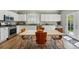 Bright kitchen boasts white cabinets, stainless steel appliances, and adjacent dining area with access to the outdoors at 531 Americana Rd, Longmont, CO 80504