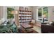 Inviting living room features a large bookshelf, comfortable seating, and ample natural light, creating a cozy ambiance at 531 Americana Rd, Longmont, CO 80504