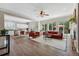 Open concept living room seamlessly connects to the kitchen, featuring hardwood floors and ample natural light from large windows at 531 Americana Rd, Longmont, CO 80504
