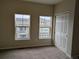 Bedroom featuring neutral carpet and paint, dual windows, and a closet with bifold doors at 9578 Pearl Cir # 105, Parker, CO 80134