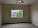 A cozy bedroom features neutral carpet, a ceiling fan, and a window view of the neighborhood at 9578 Pearl Cir # 105, Parker, CO 80134