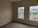 Bedroom featuring neutral carpet and paint with a bright, neighborhood view from dual windows at 9578 Pearl Cir # 105, Parker, CO 80134