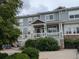 Two story home features a covered porch, green foliage and a partial stone facade at 9578 Pearl Cir # 105, Parker, CO 80134