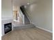 Spacious living room with hardwood floors and a cozy fireplace, leading to carpeted stairs at 9578 Pearl Cir # 105, Parker, CO 80134