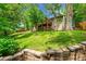 Beautiful backyard featuring a green lawn, stone retaining walls, and a partially shaded area at 10224 W 68Th Way, Arvada, CO 80004