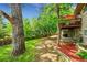 Lush backyard with mature trees, garden beds, and a back deck, creating a serene outdoor space at 10224 W 68Th Way, Arvada, CO 80004