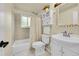 Bathroom featuring tile flooring, a bathtub with shower, toilet, sink, and decorative mirror at 10224 W 68Th Way, Arvada, CO 80004