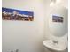 Small powder room is equipped with a modern sink, a round mirror and decorative wall art at 4431 N Quatar Ct, Aurora, CO 80019