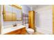 Modest bathroom with a toilet, shower and tub combo, a sink and mirror combo, and an organizing shelf at 598 S Navajo St, Denver, CO 80223