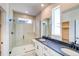Bathroom with tiled glass shower and double sink vanity with dark countertop at 8509 Orchard City Dr, Littleton, CO 80125