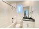 Bathroom with a tiled shower-tub, dark fixtures, toilet and vanity with dark countertop at 8509 Orchard City Dr, Littleton, CO 80125