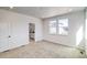 Light bedroom with plush carpet, large windows, and a bathroom suite entrance at 8509 Orchard City Dr, Littleton, CO 80125