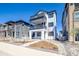 Charming three-story home featuring double balconies, a modern white facade, and professional landscaping at 8509 Orchard City Dr, Littleton, CO 80125