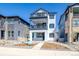 Charming three-story home featuring double balconies, a modern white facade, and professional landscaping at 8509 Orchard City Dr, Littleton, CO 80125
