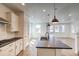 Bright, open-concept kitchen featuring a large island, stainless steel appliances, and access to the patio at 8509 Orchard City Dr, Littleton, CO 80125