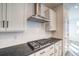 Close-up of modern kitchen featuring stainless steel gas range, subway tile backsplash, and dark countertops at 8509 Orchard City Dr, Littleton, CO 80125