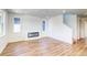 Bright living room featuring wood floors, a fireplace, and large windows for natural light at 8509 Orchard City Dr, Littleton, CO 80125