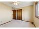 This bedroom features neutral walls, and a closet with wooden doors at 7288 S Zephyr Way, Littleton, CO 80128