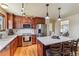 Open kitchen featuring stainless steel appliances, custom cabinetry, and a functional center island with bar seating at 7288 S Zephyr Way, Littleton, CO 80128