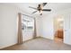 Bedroom with view to bathroom featuring a ceiling fan, window, and plush carpeting at 23505 E Platte Dr # 8D, Aurora, CO 80016