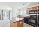 Bright kitchen with wood cabinets, black appliances, an island and large windows at 23505 E Platte Dr # 8D, Aurora, CO 80016