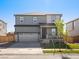 Charming two-story home with a well-manicured lawn, front porch, and two car garage at 8850 Sedalia St, Commerce City, CO 80022