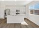 Bright kitchen features white cabinets, stainless steel appliances, granite counters and large island at 8850 Sedalia St, Commerce City, CO 80022