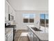 Bright kitchen features white cabinets, stainless steel appliances, granite counters and view to backyard at 8850 Sedalia St, Commerce City, CO 80022