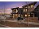 Modern townhouse exterior with brick facade, metal accents, and private balconies at dusk at 2466 S Delaware St # 3, Denver, CO 80223
