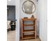 Hallway space with wood shelving unit, round mirror, and entry into a bedroom at 2466 S Delaware St # 3, Denver, CO 80223